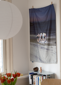 Room interior with a table, vase of flowers, and a wall hanging.